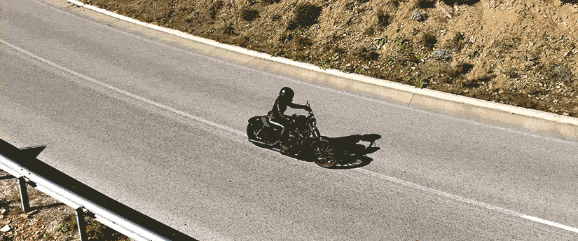 A motorcyclist navigates a winding road, embodying the spirit of exploration and thrill.