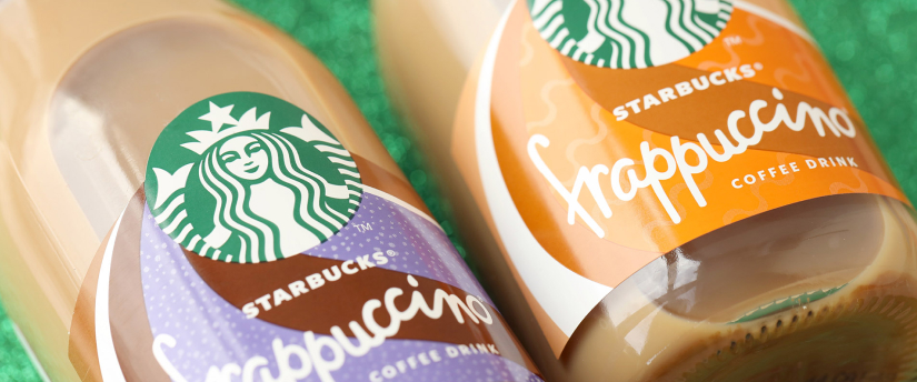 A display of Starbucks coffee bottles featuring various flavors arranged neatly on a shelf.