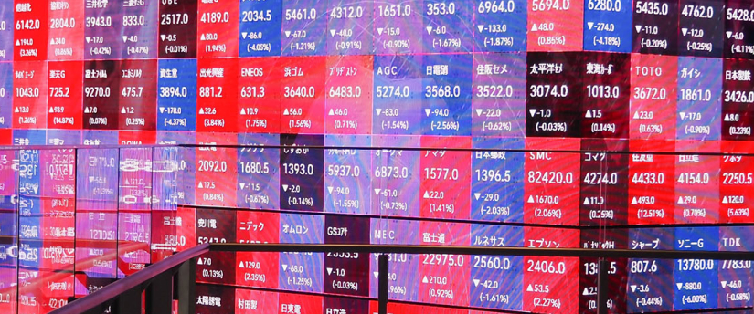 A man observes a wall adorned with colorful stock market information, highlighting various financial data and trends.