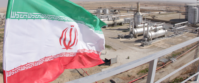 An Iranian oil station with industrial equipment and large storage tanks in the background, representing the country's oil industry