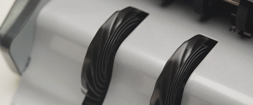 A close-up view of two black and white paint rollers resting side by side on a surface.