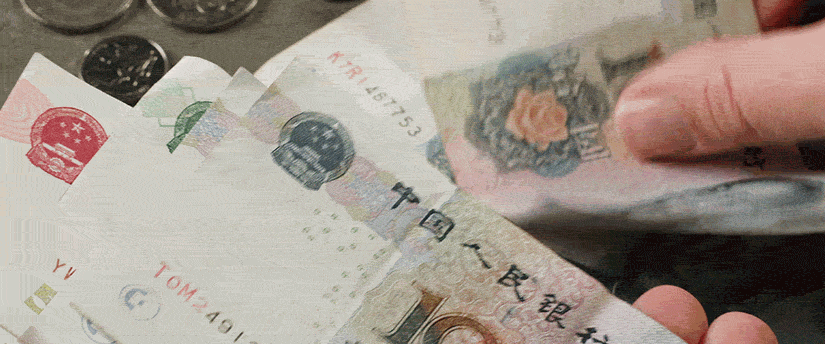 An individual meticulously counts Chinese currency, with numerous bills displayed, symbolizing wealth and cash flow.