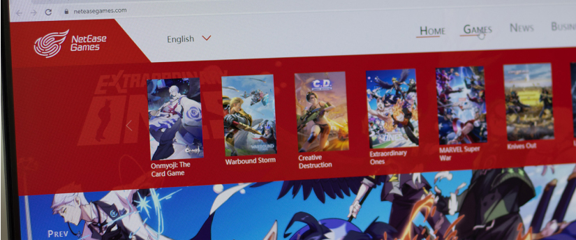 The image features a computer screen showcasing a red and white website, representing NetEase's presence in the Chinese gaming sector.