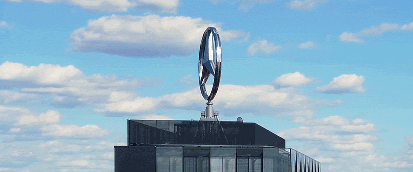 Mercedes-Benz symbol mounted on a building, showcasing the iconic silver three-pointed star enclosed in a circle, prominently displayed against the structure