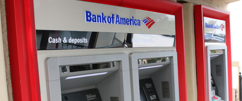 A Bank of America ATM machine, featuring a clear display and card slot, set against a neutral background for easy identification.
