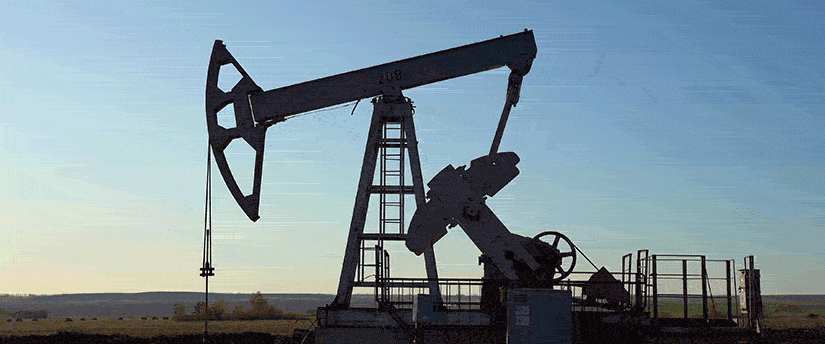 A solitary oil pump operates in the center of a sprawling field, highlighting the intersection of industry and nature.
