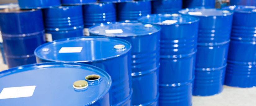 An expansive view of a warehouse containing a multitude of blue barrels arranged systematically for storage.