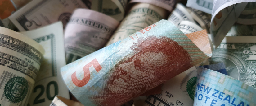 A close-up image of a pile of U.S. dollars stacked together, showcasing various denominations and crisp banknotes.