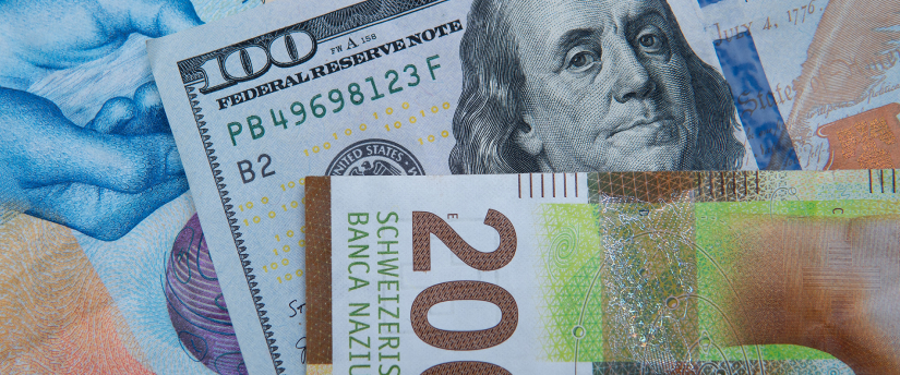 A euro coin placed directly on top of a US dollar coin, illustrating the comparison between the two currencies.