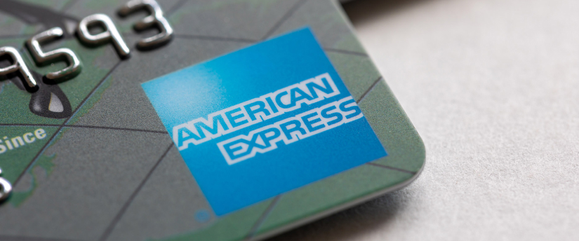 A close-up of an American Express credit card, featuring the iconic logo and card details against a neutral background.