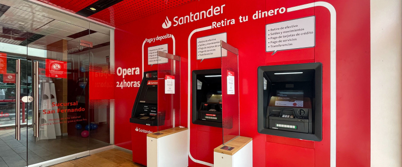 A red and white ATM machine located inside a store, prominently displayed for customer use.
