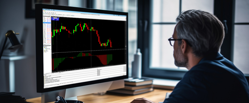 A man focuses on a computer screen that shows a trading indicator, evaluating financial market information.