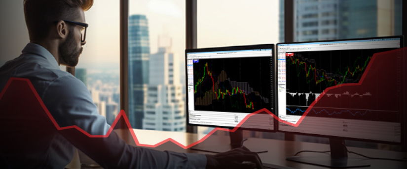 A man seated at a desk, analyzing forex stock market graphs on two computer monitors.