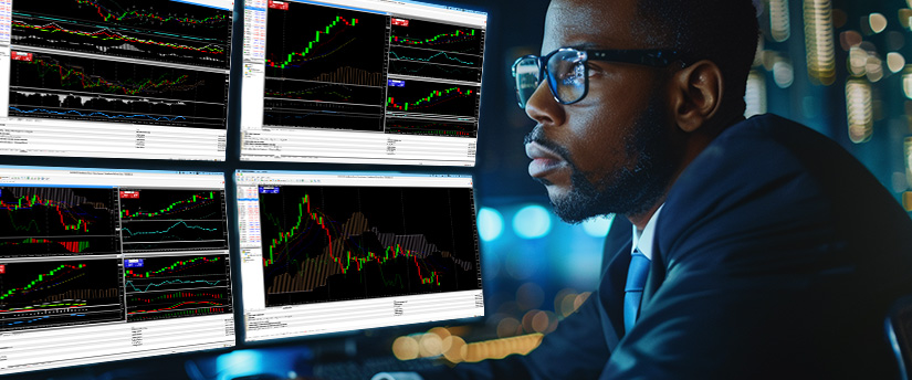 A focused Black man in glasses views multiple monitors displaying financial trading charts, illustrating forex fundamental analysis in a professional setting.